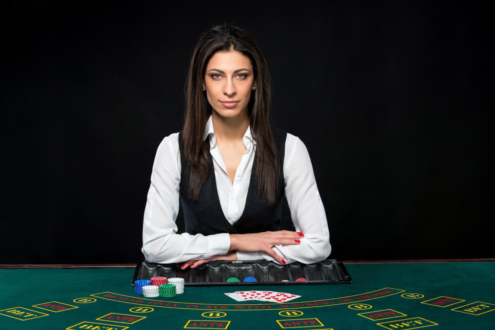 Como jogar jogos de cassino? Algumas dicas de Jogos 5 beautiful girl dealer table game poker dealer deals cards he is looking camera