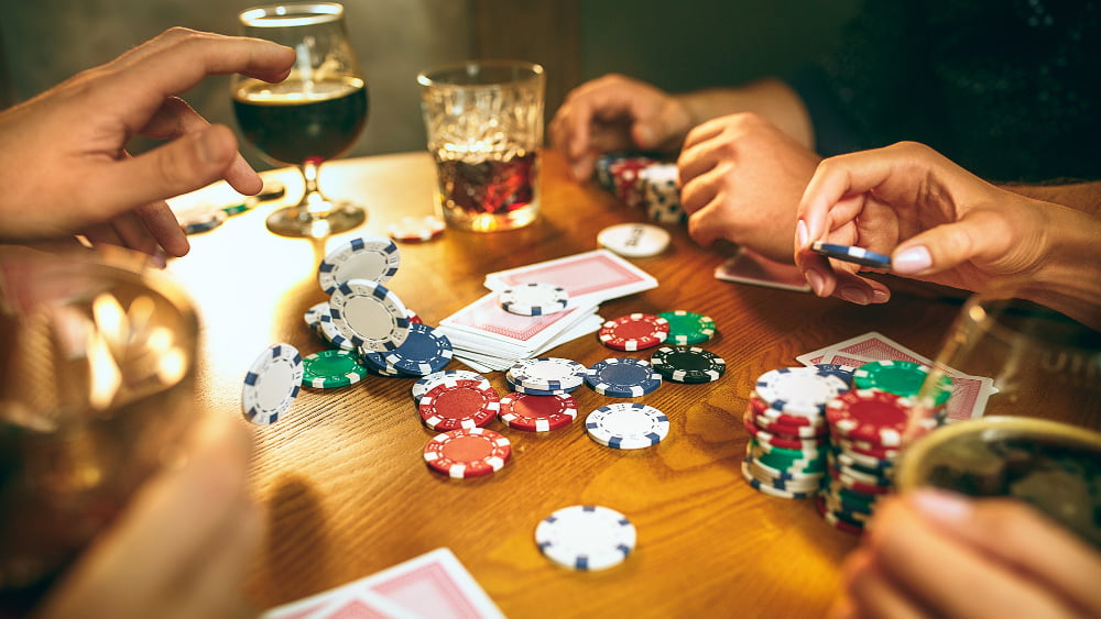 Como jogar jogos de cassino? Algumas dicas de Jogos 4 men women playing card game poker evening entertainment excitement concept